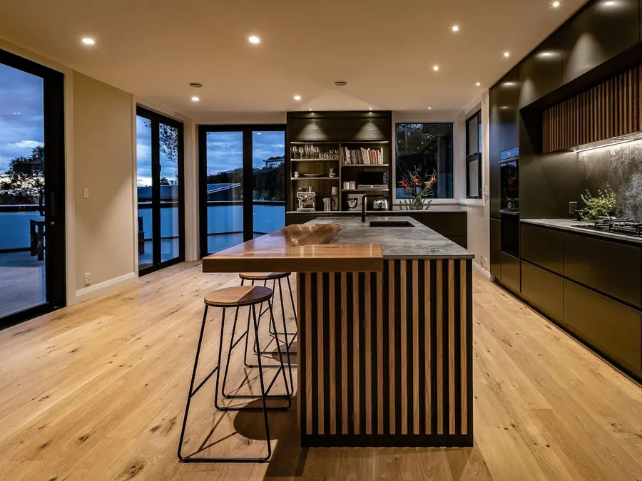 The island and full-height cabinetry, with glass doors out to the deck