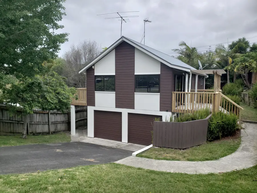 After: the house in white and brown with a new timber deck