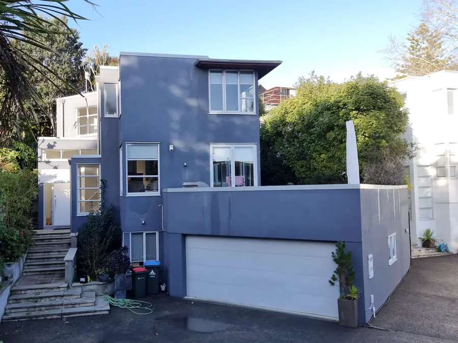 Before: the same house with weathered blue plaster cladding